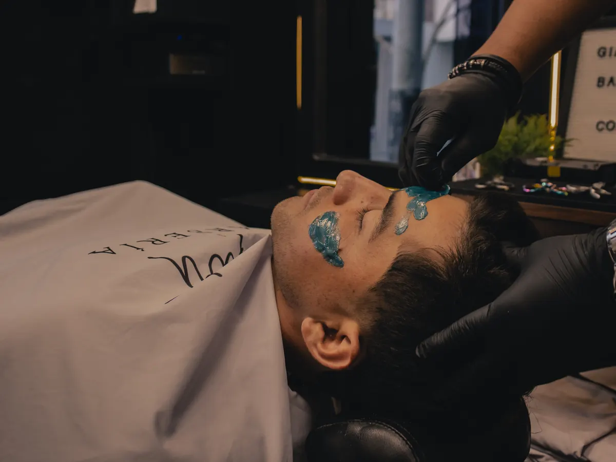 Aplicación de cera en el rostro durante la depilación facial